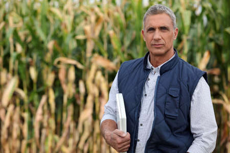 Farmer in a field with a laptop computerの写真素材