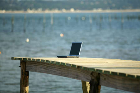 A laptop left on a pierの写真素材
