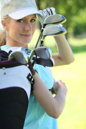 Woman with golf clubsの写真素材