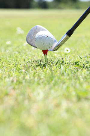 Closeup of a golf ball, club and teeの写真素材