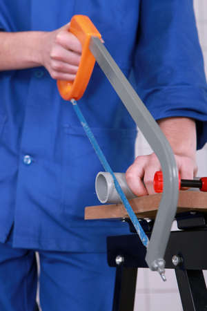 Plumber sawing grey plastic pipeの写真素材