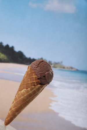 chocolate ice cream cone close up against tropical beach background
