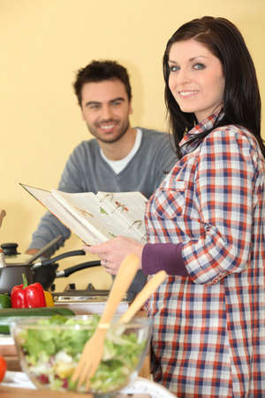 Cheerful woman with cookbookの写真素材