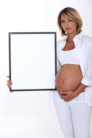 Pregnant women holding picture frameの写真素材