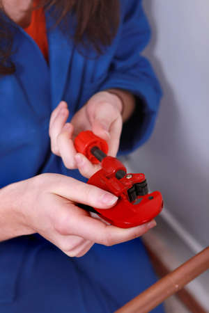 Female plumber with a pipe cutterの写真素材