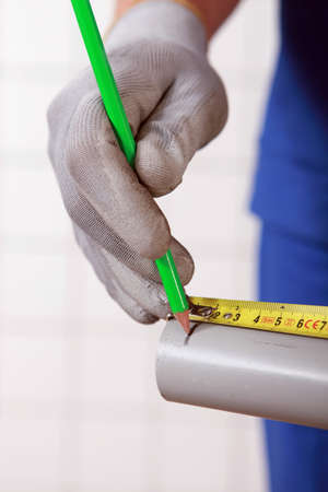 Worker marking a measurement on a tubeの写真素材