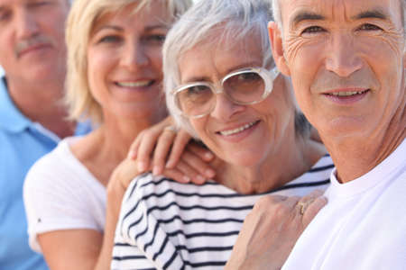 Closeup of two older couples out in the sunshine