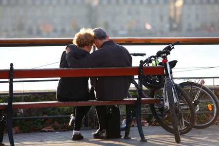 Couple sitting on a riverside benchの写真素材