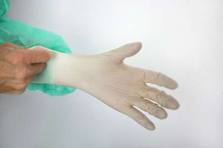 Surgeon putting on a rubber gloveの写真素材