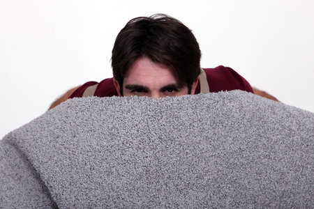 Man hiding behind a roll of carpet