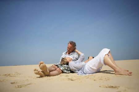 Couple laying in the sandの写真素材