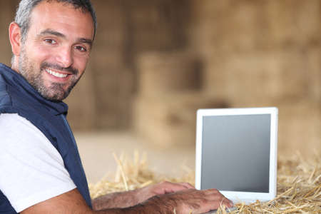 Man using laptop on a farmの写真素材