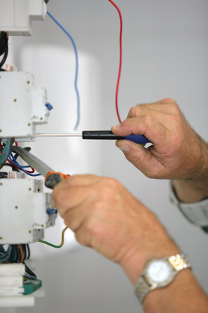 Electrician repairing a fuse box