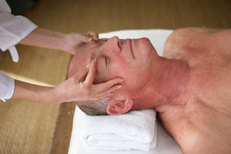 senior man having a massage in a spa centerの写真素材