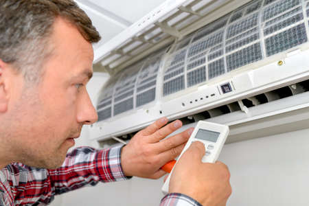 Man repairing air conditioning unitの写真素材