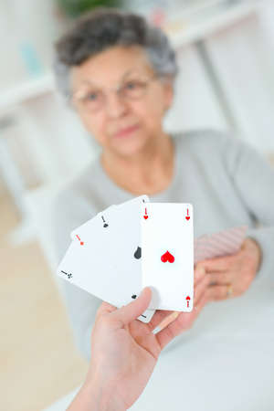 Old lady playing a card gameの写真素材