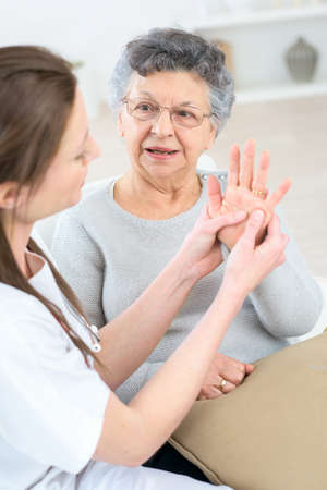 Checking an old lady's handsの写真素材