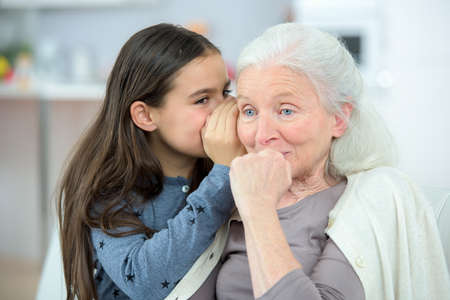 Little girl and grandma whispering secretsの写真素材
