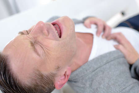 Young man suffering from heart painsの写真素材