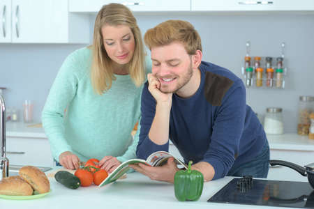 Couple following recipe from a magazineの写真素材