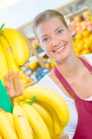 Shop assistant holding bananasの写真素材
