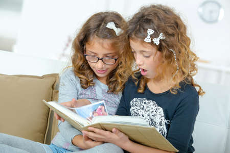 Two sisters reading a bookの写真素材