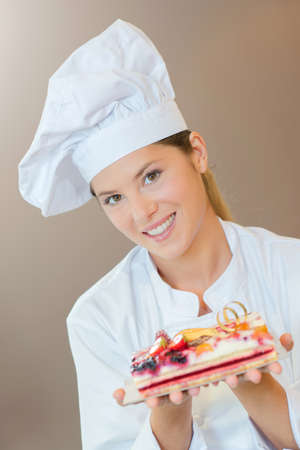 Female bakery chef with a fruit cakeの写真素材