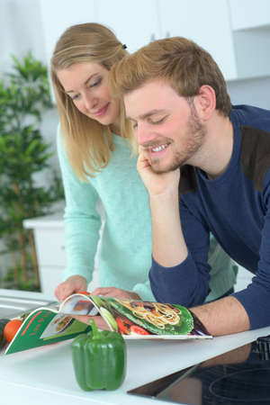 Couple following recipe from a magazineの写真素材