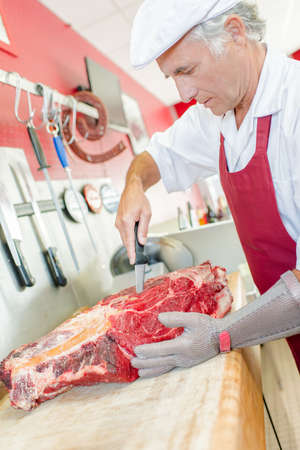 Butcher is skilled in preparing meatの写真素材