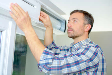 Handyman installing a window shutterの写真素材