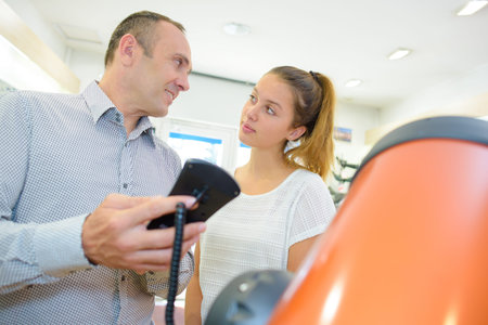 Man showing young lady the controls of a telescopeの写真素材