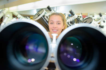 Closeup of binoculars, lady in backgroundの写真素材