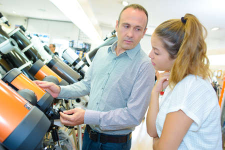Man and young lady looking at telescopesの写真素材