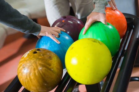 Three friends choosing their bowling ballsの写真素材