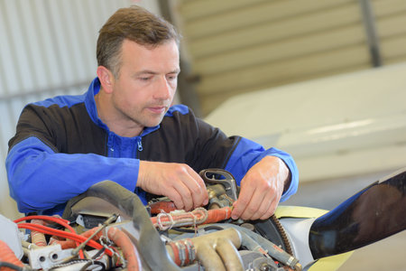Man working on wiring of aircraft