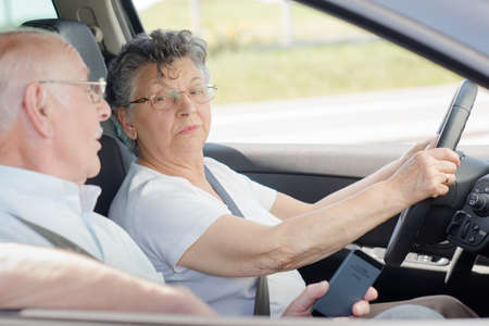 Elderly lady driving, husband talking to herの写真素材