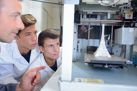 Students and teacher watching experiment with model Eiffel Tower
