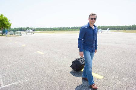 Man walking with suitcase at airportの写真素材