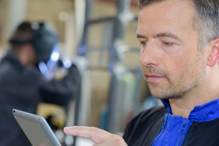 Closeup of workman using tabletの写真素材