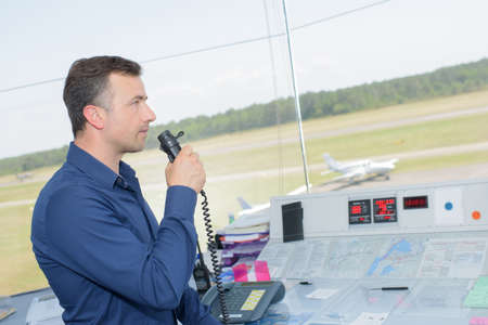 Man in control tower talking into microphoneの写真素材
