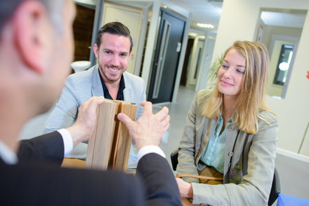 Salesman demonstrating materials to coupleの写真素材