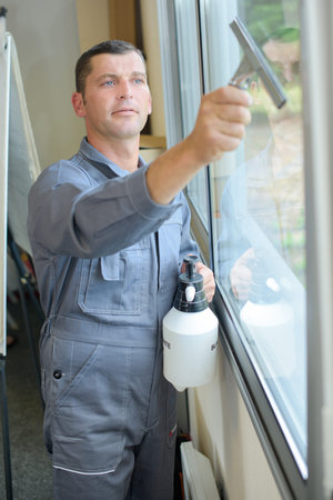 Man cleaning window indoors