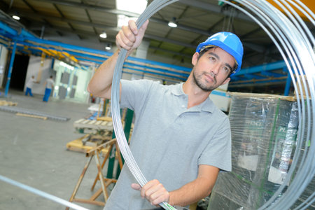 young man holding a wire rollの写真素材