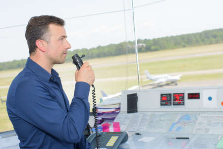 Man in control tower speaking into microphoneの写真素材