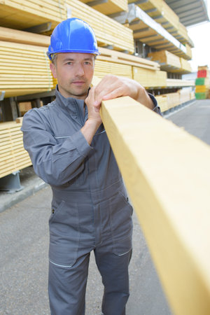 man carrying plank
