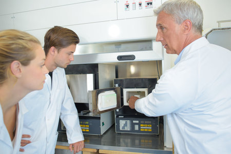 Technician putting product into appliance, trainees watching