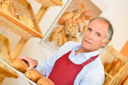 Baker carrying bread on a trayの写真素材