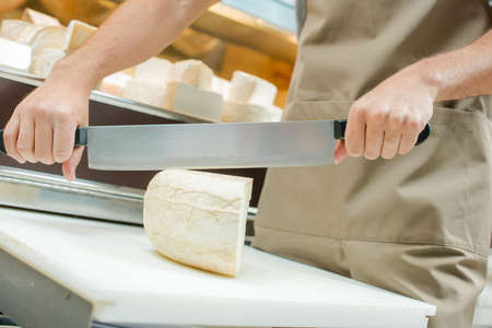 Slicing a block of cheeseの写真素材
