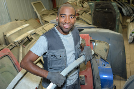 worker sorting old vehicle body