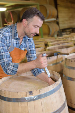 wood barrels production cooper using hammer and tools in workshopの写真素材